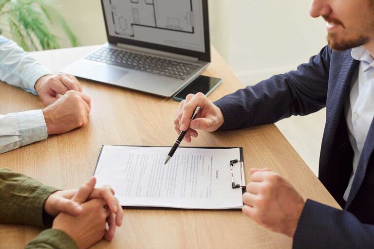 A person reviews a will and estate documents at a desk with family photos and paperwork.